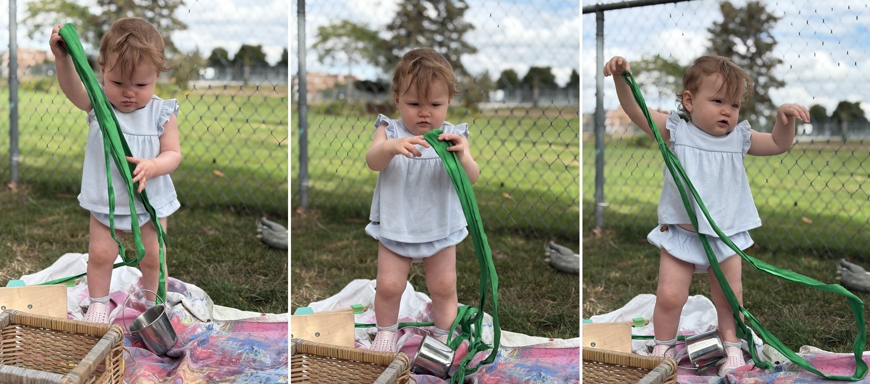 A toddler exploring a long green ribbon outdoors